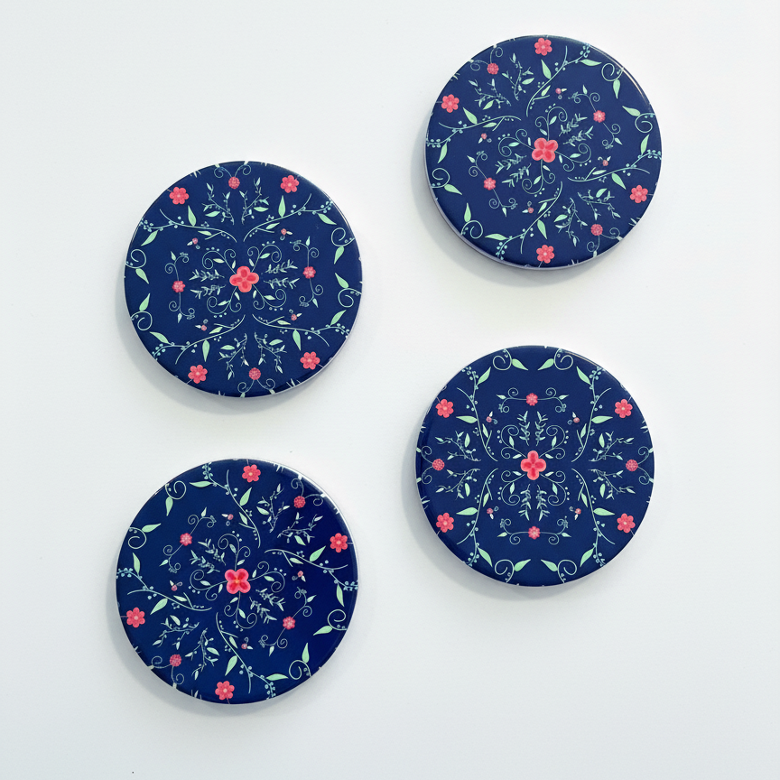 Four navy blue coasters with floral patterns on a white background